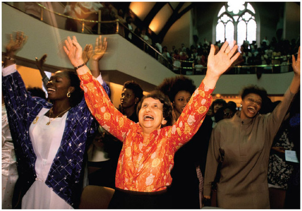 Pentecostals lift their arms in holy ecstasy during an Elim Pentecostal Church service at Kensington Temple in London, England.